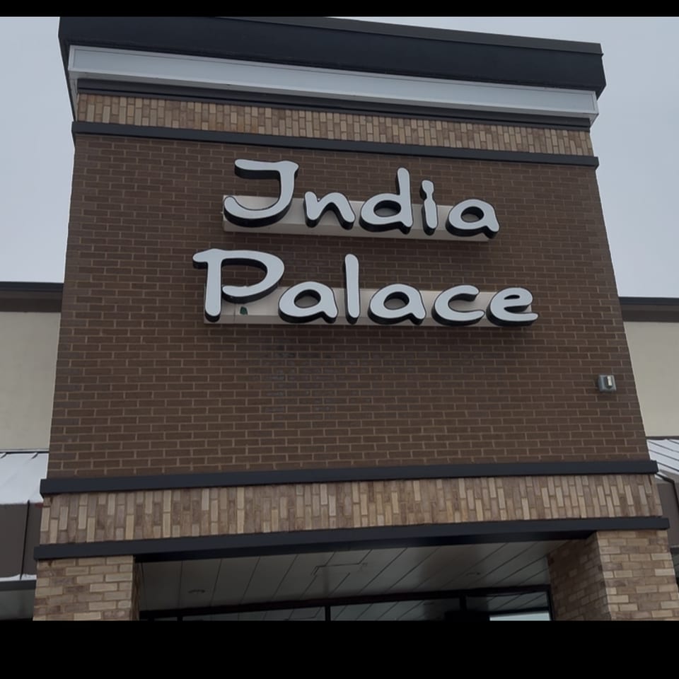 India Palace restaurant sign with white letters on a brown brick building exterior.